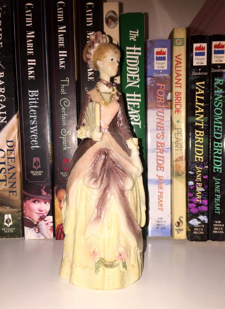 Photo of porcelain figurine of woman dressed in 19th century gown.